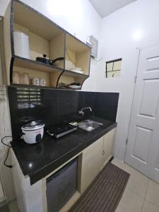 a small kitchen with a sink and a counter at Casa Feliz Apartments Baguio in Baguio