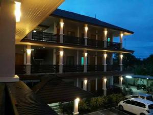 a building with a car parked in a parking lot at night at Mgrand Hotel in Ban Non Sombun +13 photos