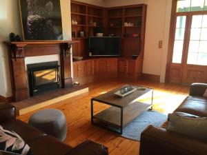 a living room with a couch and a fireplace at CLAYFIELD HOMESTEAD - rustic country accommodation in Bishopsbourne