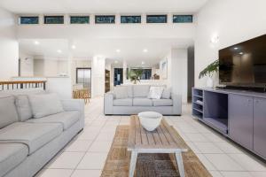 un salon avec deux canapés et une cuisine dans l'établissement Currumbin Beachside Retreat, à Gold Coast