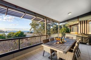 une salle à manger avec une table et des chaises sur un balcon dans l'établissement Currumbin Beachside Retreat, à Gold Coast