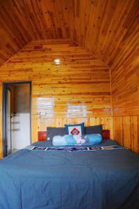 a bedroom with a blue bed in a wooden wall at MAMA LILI'S HOMESTAY in Hao Su Ngai