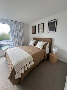 una camera da letto con un letto grande e una finestra di Luxury And Serene 2 Bed Near CBD With Parking a Christchurch Altre 14 foto