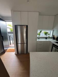 una cucina con frigorifero in acciaio inossidabile di Luxury And Serene 2 Bed Near CBD With Parking a Christchurch