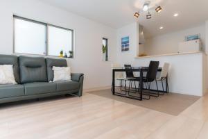 a living room with a couch and a table at Naha Airport NewVilla 4 bedrooms, 2 modern bathrooms, 3 FREE parking in Itoman