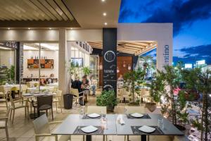 a restaurant with tables and chairs and people sitting at tables at Oscar Suites & Village in Agia Marina Nea Kydonias