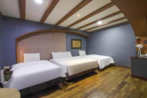 a row of beds in a room with blue walls at Hotel Tate V in Suwon +4 photos