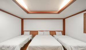 a row of beds in a room with a ceiling at Hotel Tate V in Suwon