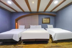 two beds in a room with blue walls at Hotel Tate V in Suwon