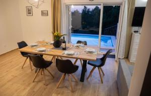 a dining room table and chairs with a view of a pool at 3 Bedroom Beautiful Home In Sutivan in Sutivan