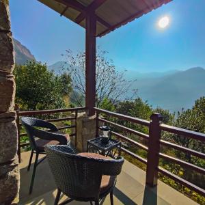 a balcony with two chairs and a table and a view at Buransh Stays - Sari in Sari +21 photos