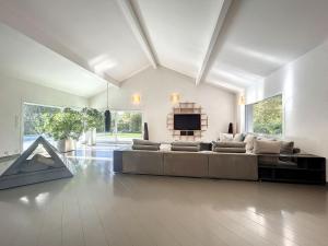 a large living room with a couch and a television at Magnifique villa au bord du lac in Messery