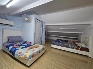 乔治市Color Mixed Home Hostel的一间卧室配有两张床和风扇 更多30张照片