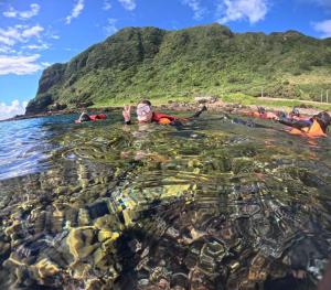 a group of people in the water at the beach at sky blue hostel in Lanyu