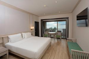 a bedroom with a large white bed and a table at Pinnacle Grand Jomtien Resort and Beach Club in Na Jomtien +137 photos