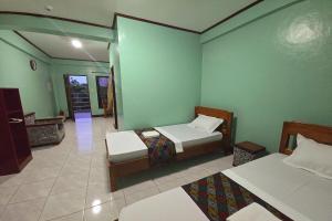a room with two beds and a room with a hallway at Nober Pension House City Center in Puerto Princesa City