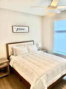 a bedroom with a large white bed with a ceiling fan at Cozy Modern 1 Bedroom Apartment in Davenport