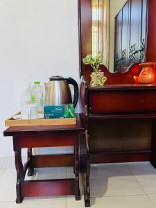 a table with a coffee pot on it next to a bed at Hamilton Mirissa in Kamburugamuwa