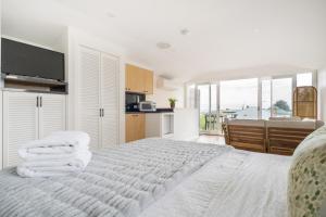a bedroom with a white bed with towels on it at By The Seaside in Mornington