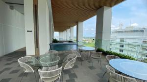 un balcon avec des tables et des chaises sur un immeuble dans l'établissement Tranquil and Comfort Living 1BR The Smith Alam Sutera Apartment By Travelio, à Tangerang
