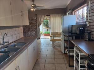 a kitchen with a sink and a refrigerator at JZ Stay in Brits
