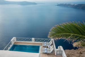 - un balcon avec vue sur l'eau dans l'établissement Prekas Apartments, à Imerovigli