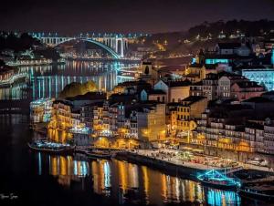 a city lit up at night with a bridge in the background at Simple but cosyBest locations in Vila Nova de Gaia