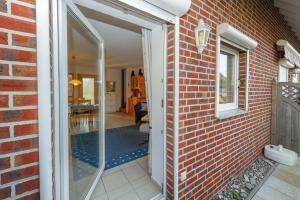 an open door to a brick house with a glass doorway at Ferienhaus Lobbe - Wohnung 3 in Lobbe
