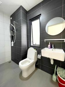 a bathroom with a toilet and a sink and a mirror at Horizon Suite Homestay, KLIA by S&T Homez in Sepang