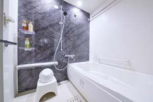 ein Bad mit einer Dusche und einem weißen WC in der Unterkunft MONday Apart Premium AKIHABARA in Tokio