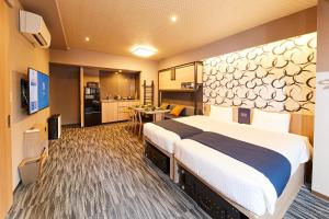 ein Hotelzimmer mit großem Bett und Küche in der Unterkunft MONday Apart Premium AKIHABARA in Tokio