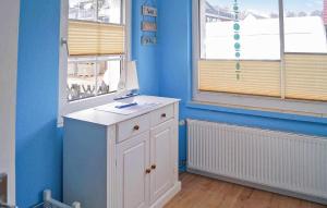 Cette chambre bleue comprend une armoire blanche et une fenêtre. dans l'établissement Ferienhaus Zinnowitz Seebad, à Zinnowitz