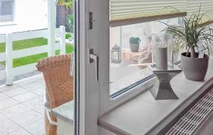 une porte coulissante en verre avec une table et des plantes en pot dans l'établissement Ferienhaus Zinnowitz Seebad, à Zinnowitz 13 autres photos