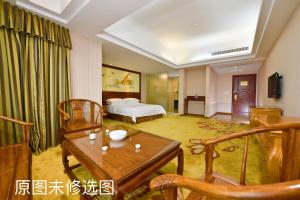 a hotel room with a bed and a table at Vienna International Hotel Jieyang Jieyanglou in Jieyang