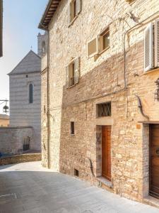 an old brick building with a church in the background at Santa Chiara Apartment in Assisi