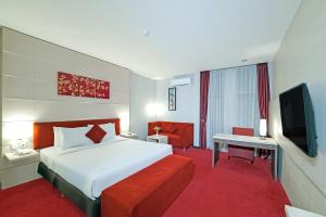 a hotel room with a bed and a television at Tjokro Hotel Klaten in Klaten +28 photos