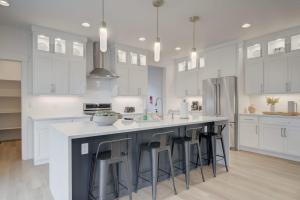 a kitchen with white cabinets and a large island with bar stools at Yellowstone Country Outdoor Adventures Sleeps 6 in Belgrade