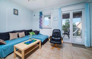 a living room with a blue couch and a chair at Beautiful Apartment In Barbariga in Barbariga