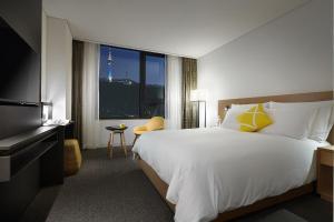 a hotel room with two beds and a television at L7 Myeongdong by LOTTE in Seoul