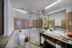 a bathroom with a toilet and a sink and a tub at Gallery Hotel & Spa - Le Pavillon Hoi An Group in Hoi An +32 photos