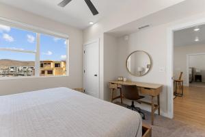 een slaapkamer met een bed, een bureau en een spiegel bij Lagoon Breeze condo in St. George