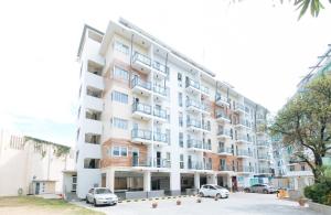 an apartment building with cars parked in front of it at RedDoorz Plus at Alpina Heights Paranaque in Manila