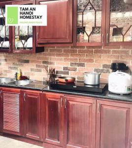 ハノイにあるHomestay Luxury HaNoiのレンガの壁、木製キャビネット付きのキッチン