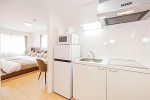 a kitchen with a white refrigerator and a bed at New-built APT at Asakusa-Skytree area with Tranquil block in Tokyo +24 photos