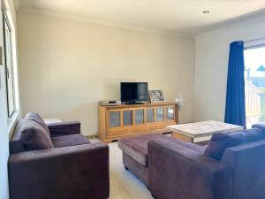 a living room with two couches and a flat screen tv at Oh Bouy, Unit 62 Seafront Estate in Jurien Bay