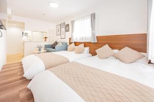 a bedroom with two beds and a couch at New-built APT at Asakusa-Skytree area with Tranquil block in Tokyo