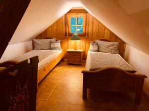 a attic bedroom with two beds and a window at Walnußhof in Schmogrow