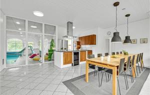 a kitchen and dining room with a wooden table and chairs at Awesome Home In Ulfborg With Kitchen in Ulfborg