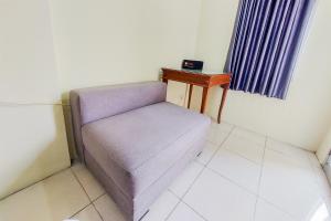 a purple chair in a room with a table at Cozy and Minimalist Studio Great Western Apartment By Travelio in Tangerang