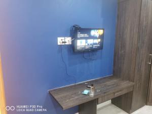 a tv on a blue wall in a room at Budias Guesthouse B&B in Kempton Park
